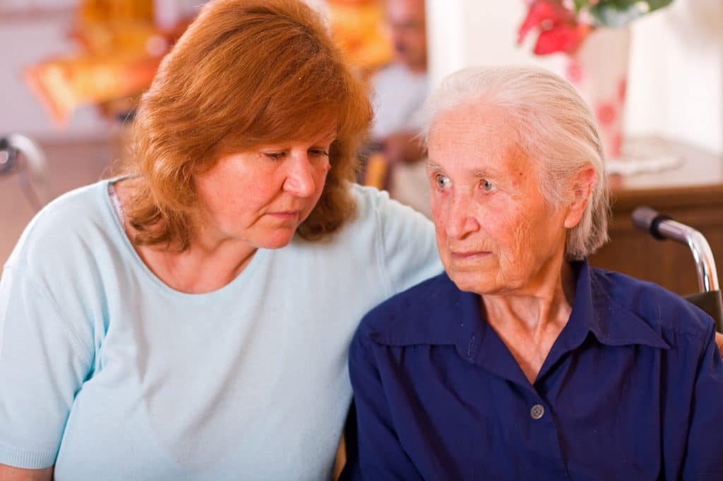 Woman sitting with senior.