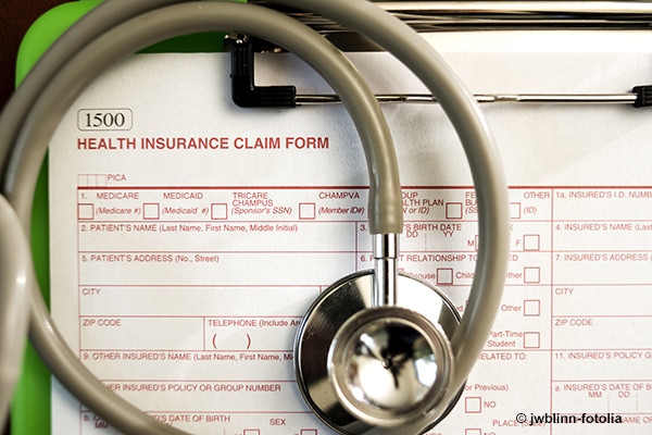 Stethoscope lying on health insurance claim form.