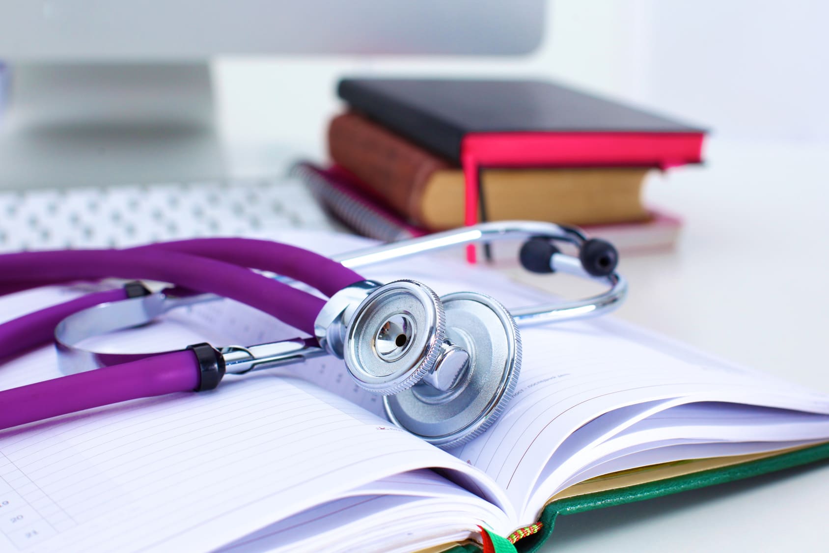 Stethoscope lying on an open book.