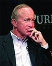 Mitch Daniels looking away with hand on chin.