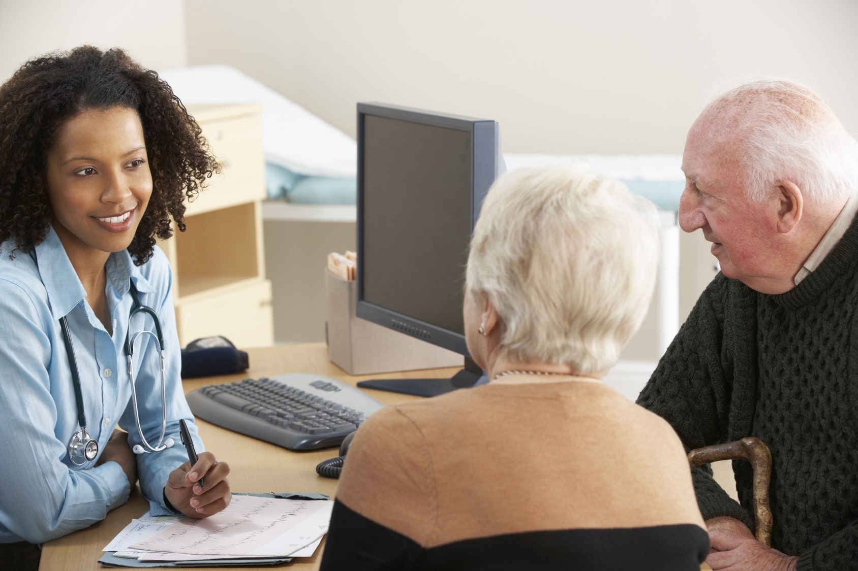 Doctor speaking with elderly couple.