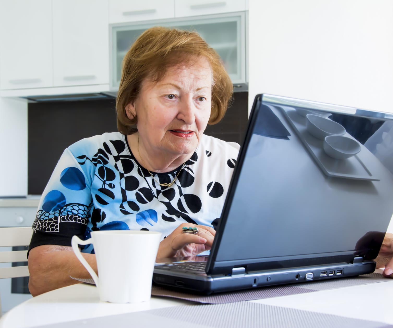Older woman using a laptop.