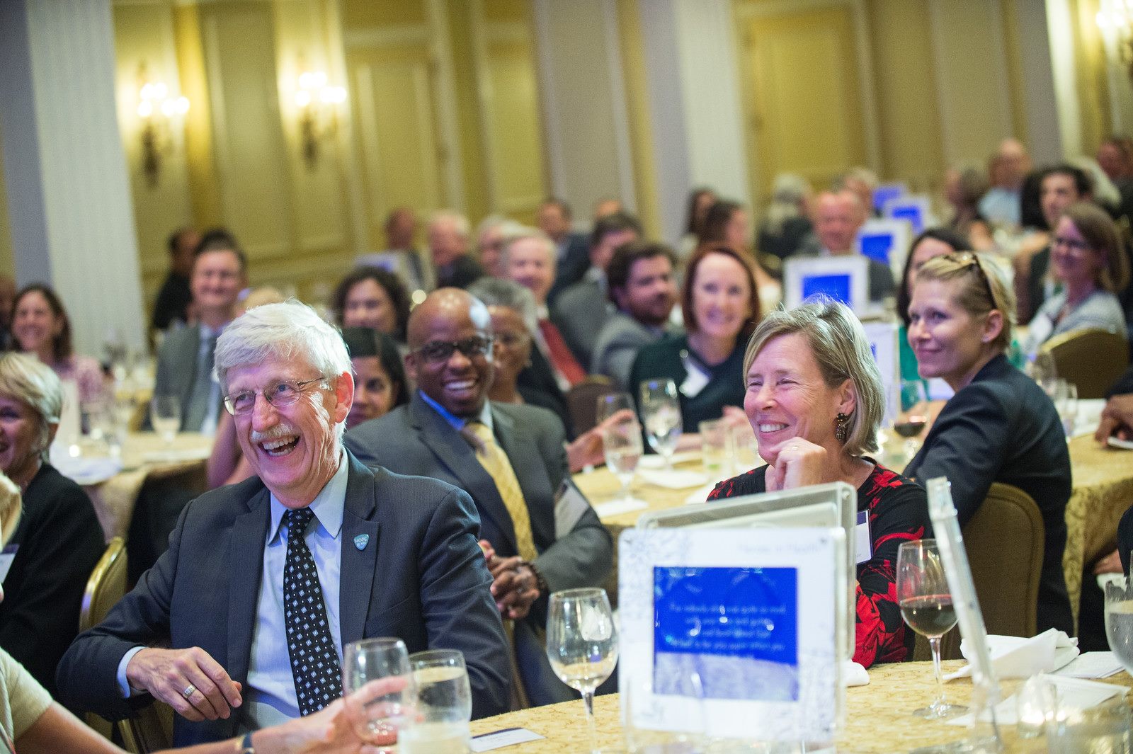 Dr. Francis Collins laughing along with guests in the audience.