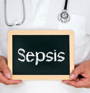 Doctor holding chalkboard with text "sepsis."