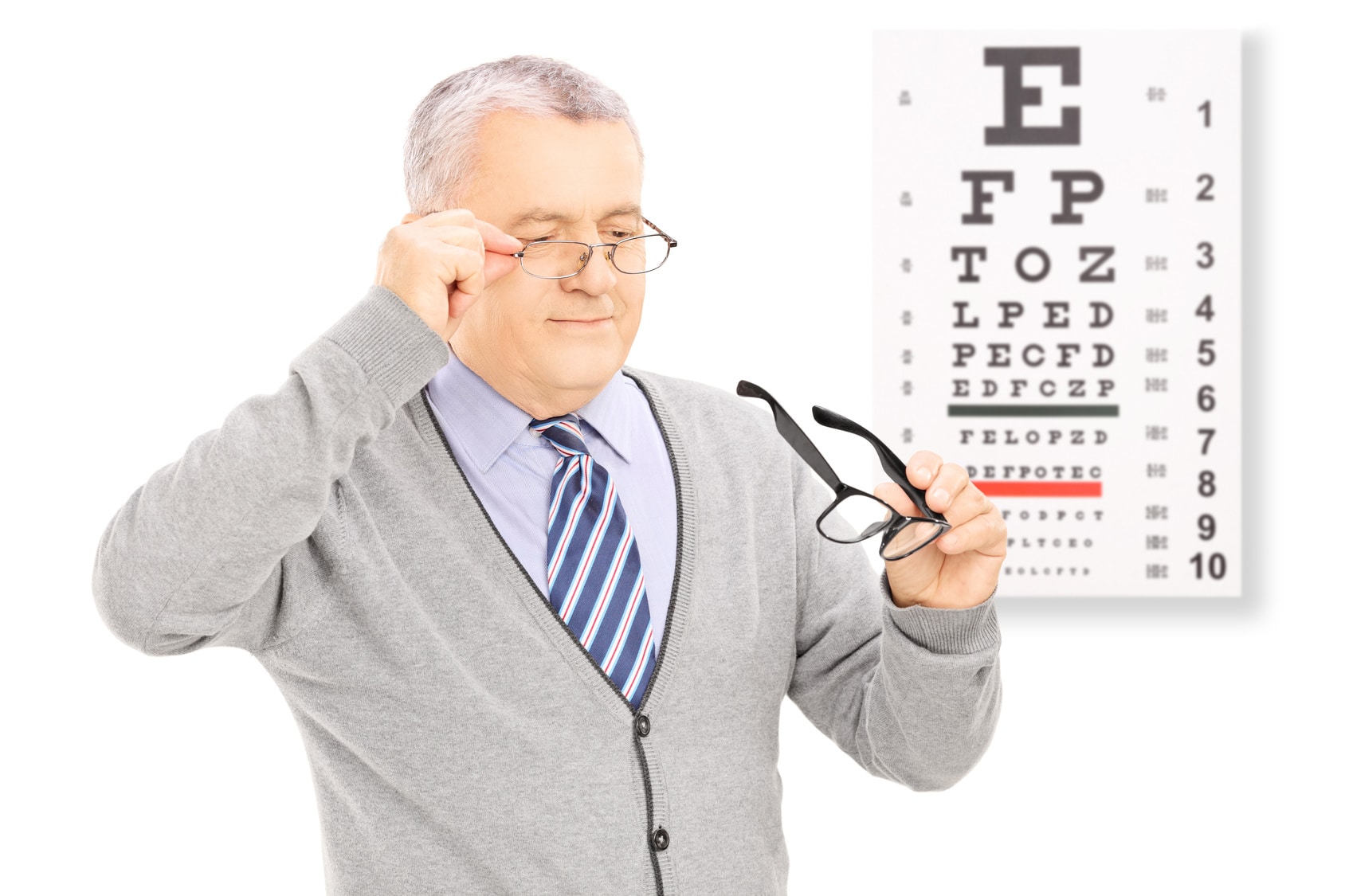 Older man trying on glasses at eye doctor.