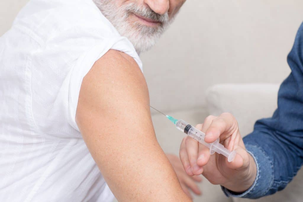 Older man receiving a vaccine.