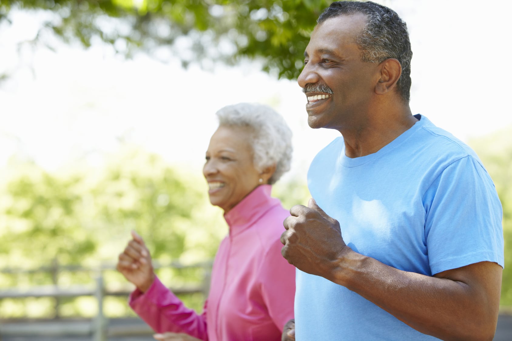 Senior couple jogging outside.