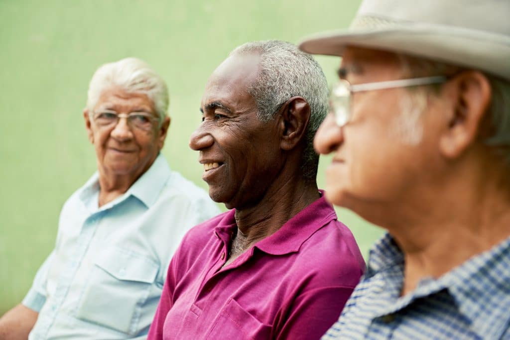 Three older men sitting together.