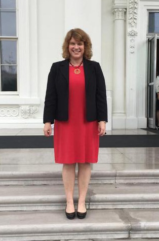 Sue Peschin standing on the steps at the White House Conference on Aging.