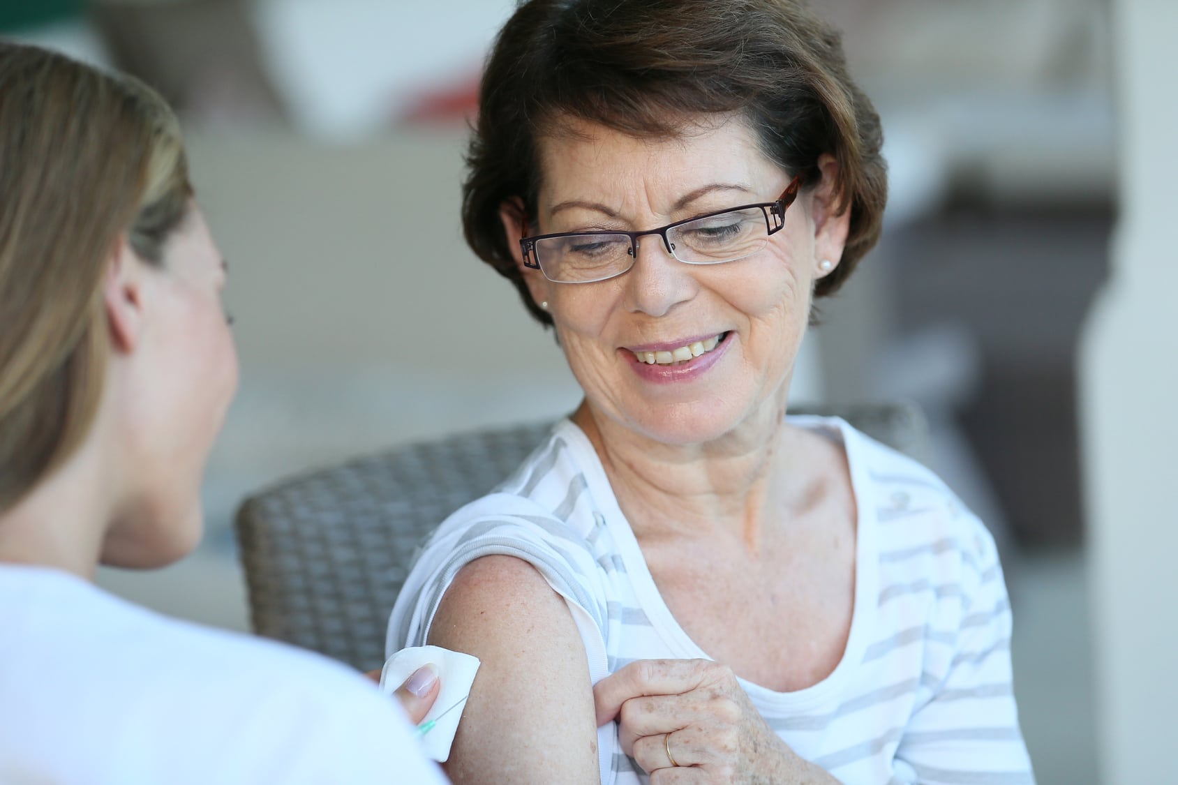 Older woman receiving a vaccine.