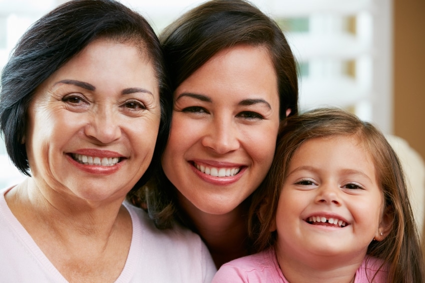 Three generations of women smiling together.