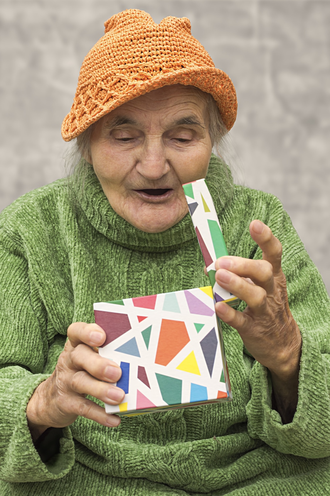 Elderly woman opening gift.