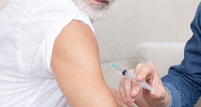 Older gentleman receiving a vaccine.