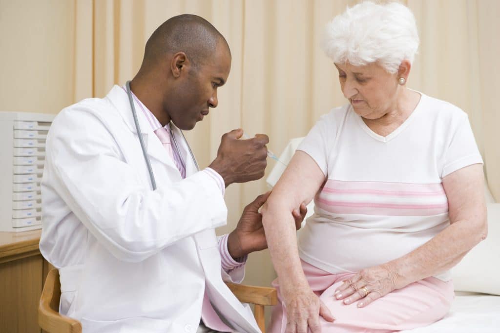 Elderly woman getting a vaccine.