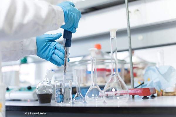 Scientist in a lab measuring liquid.