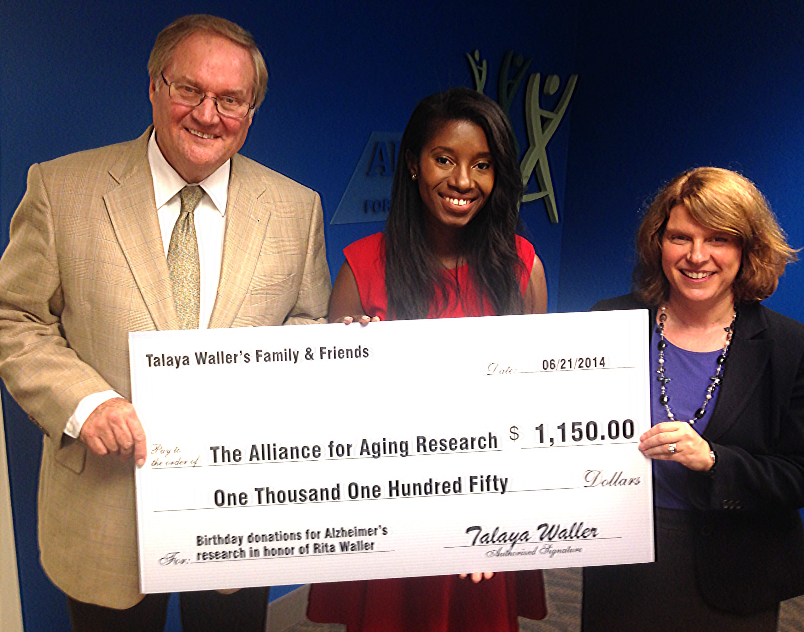 Sue Peschin and Dan Perry accepting a large check from Talaya Waller.