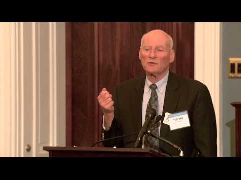 Dr. Harvey Jay Cohen speaking at a podium.