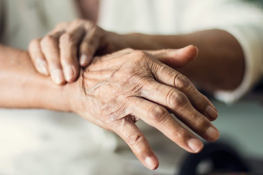 Senior holding their wrist.