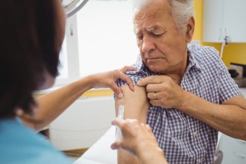 Elderly man receiving a vaccine.