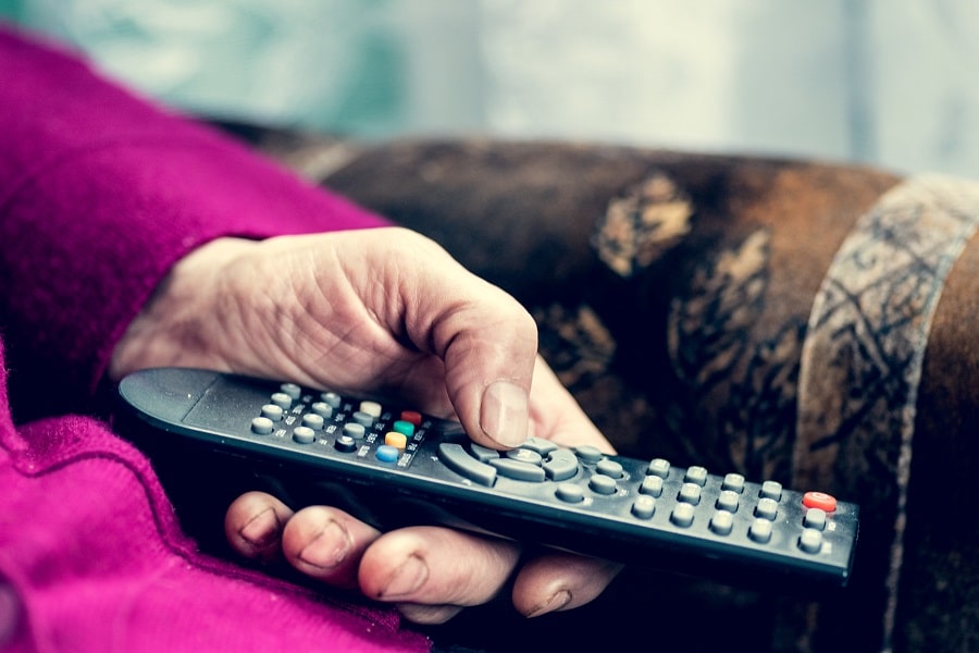 Senior using a TV remote.