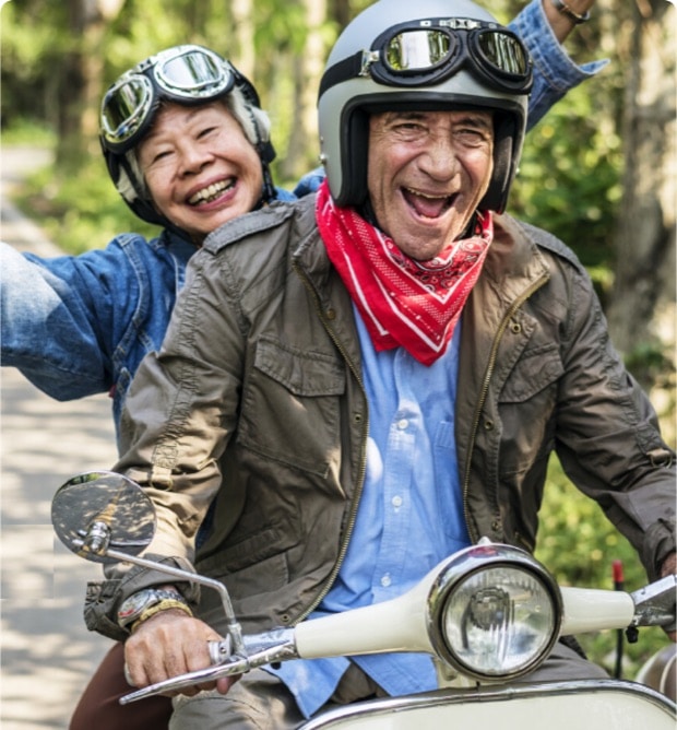 Elderly couple riding motorbike.