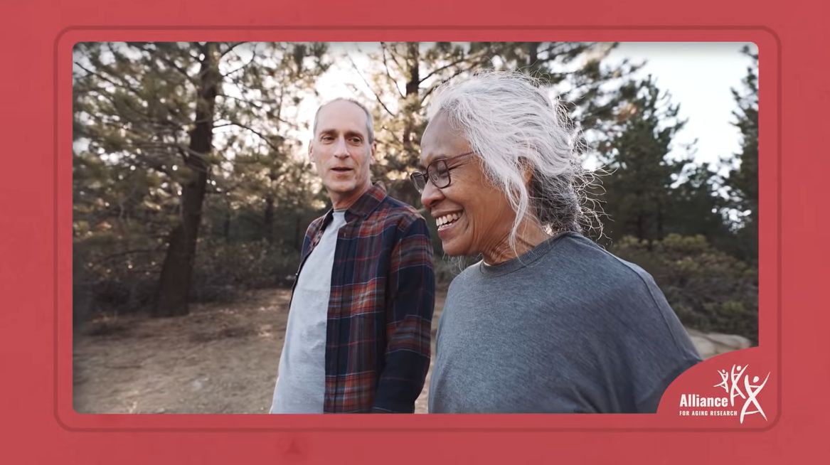 Two aging adults taking a hike among trees.