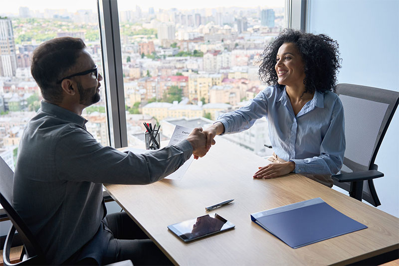 Two business people shaking hands in an office.