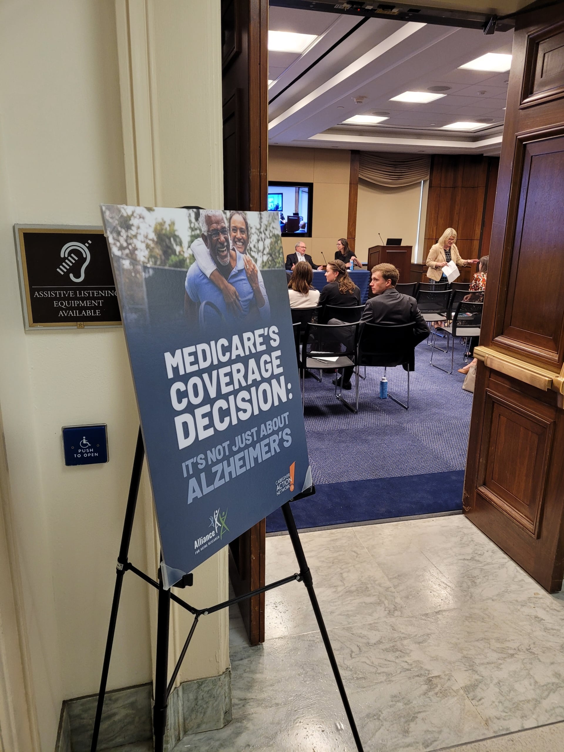 A sign outside the July 11 Hill staffer briefing reads "Medicare's Coverage Decision: It's Not Just About Alzheimer's."