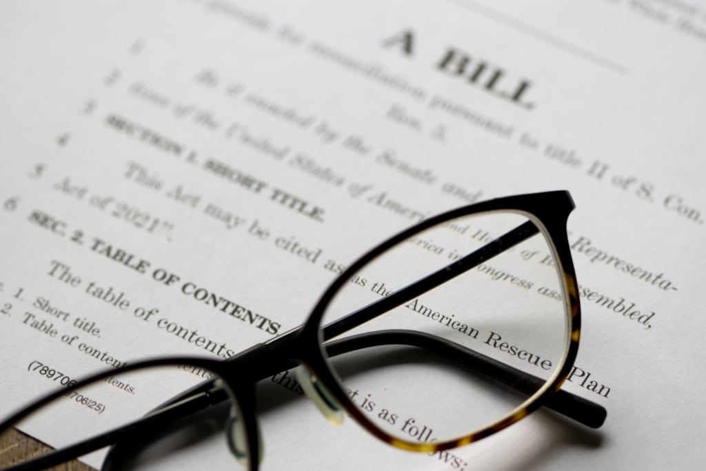A pair of black glasses on top of a typed document the with word "Bill" at the top.