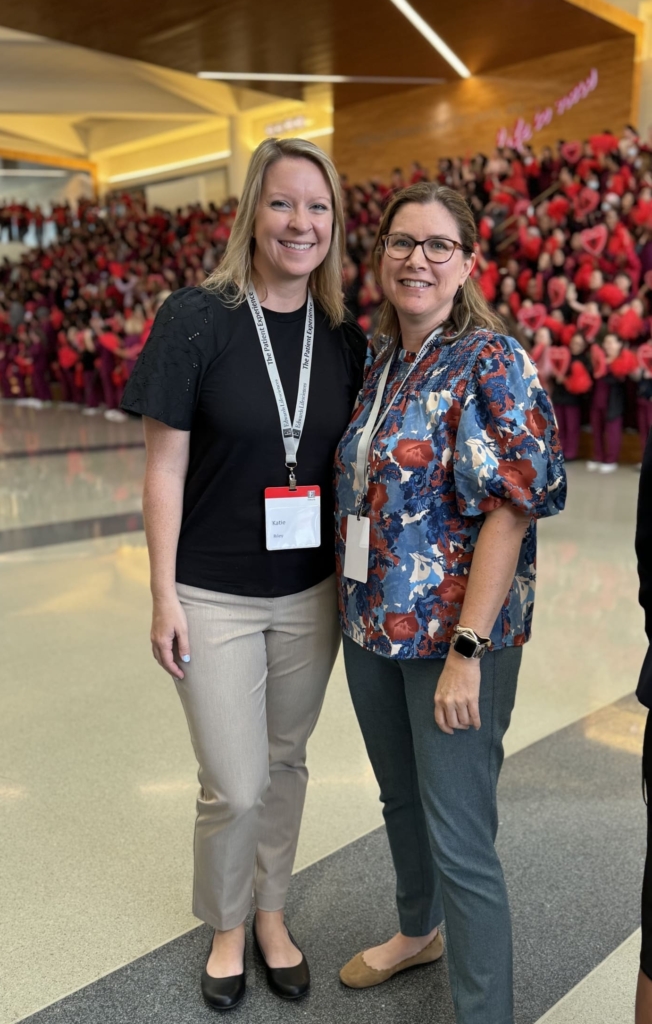 Alliance Vice President of Communications Katie Riley and Senior Vice President of Health Education & Advocacy enjoy the clap-in welcome tradition at Edwards Lifesciences on May 9. An entire shift of valve sewers cheer for arriving patients in the background.