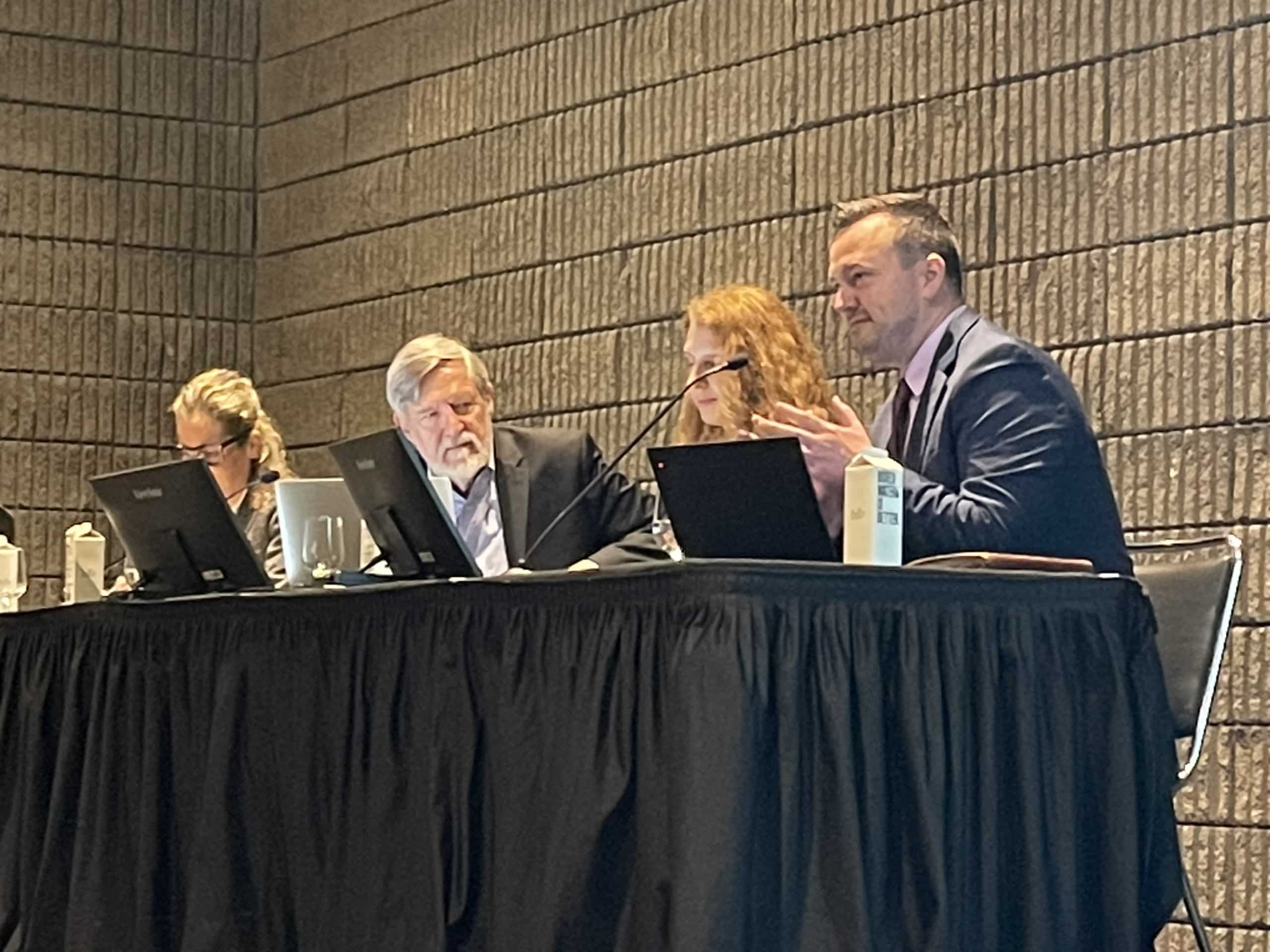 Seated on a stage with three others, Michael Ward, Alliance Vice President of Public Policy and Government Affairs, speaking on a panel at ISPOR 2024.