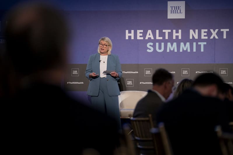 Alliance for Aging Research President & CEO Sue Peschin addressing the crowd with observers blurred in the foreground.