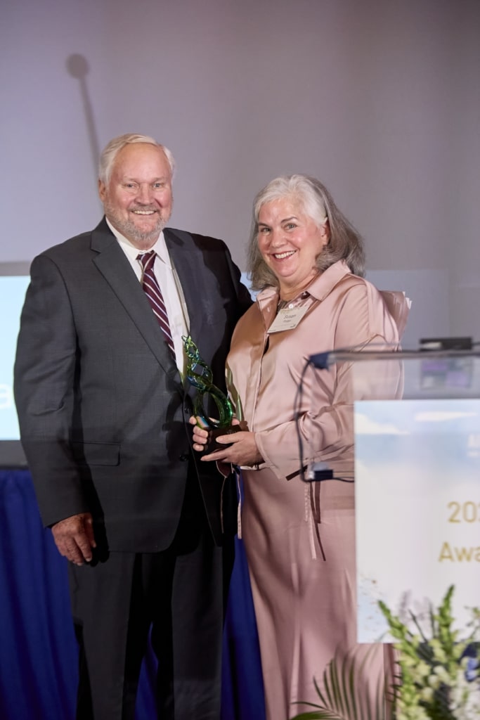 Dr. Susan Polan accepts the award for Dr. Benjamin from Dan Perry.