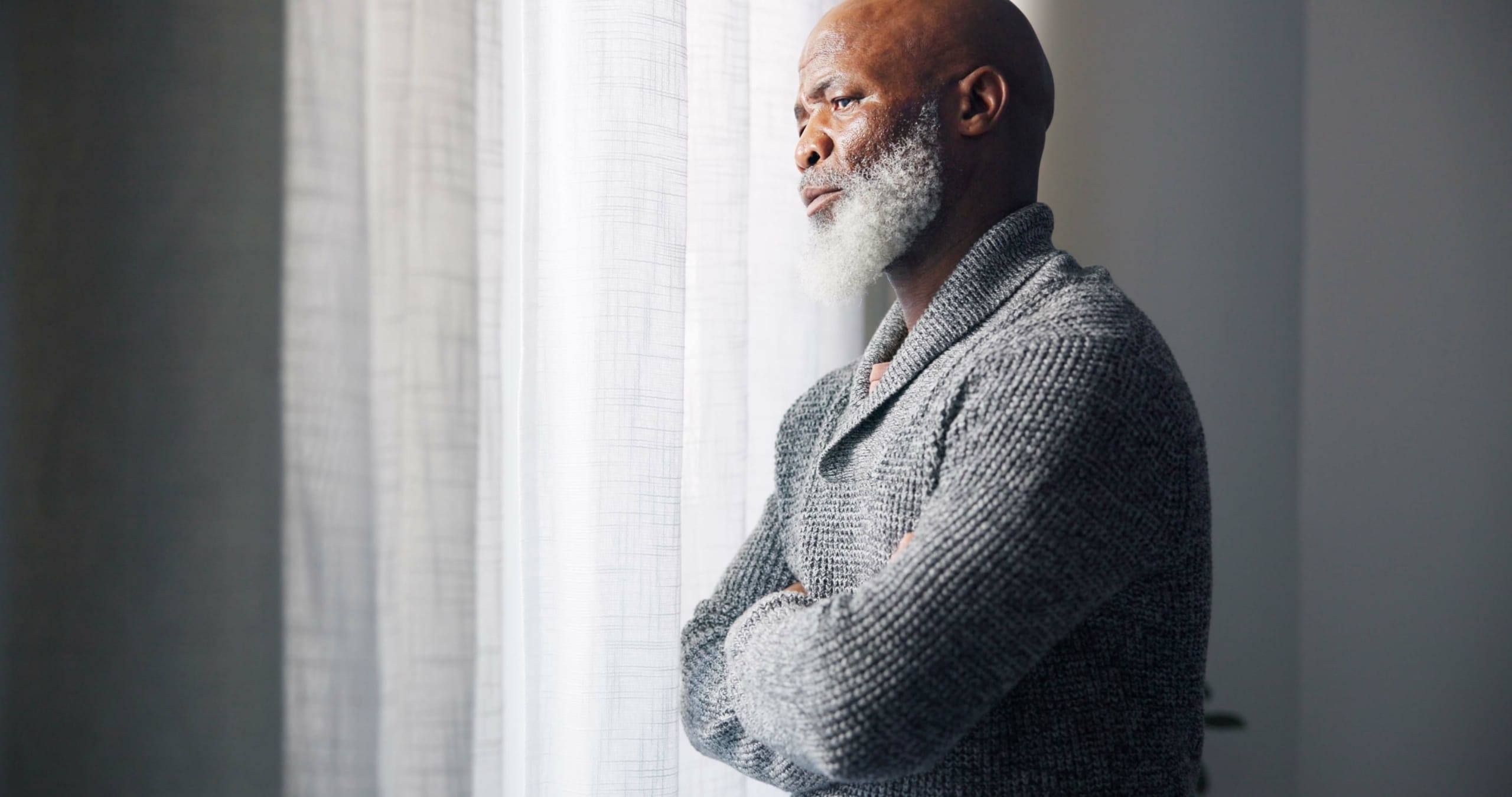 Depressed, sad and senior man in home with mourning and memory with mental health problem. Elderly male person, sorry and anxiety in a house feeling disappointed in retirement with grief and fail.