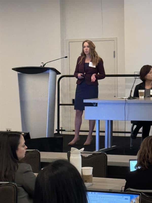 Carrie Rubel, Ph.D. speaking at the podium