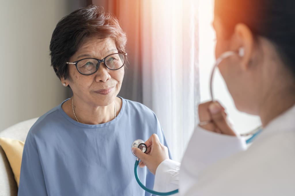 Older Asian woman having heart listened to