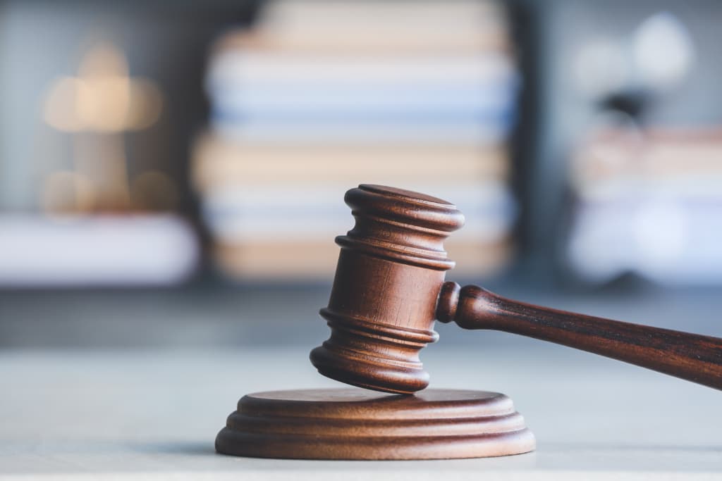 Judge's gavel on table in office with blurred background